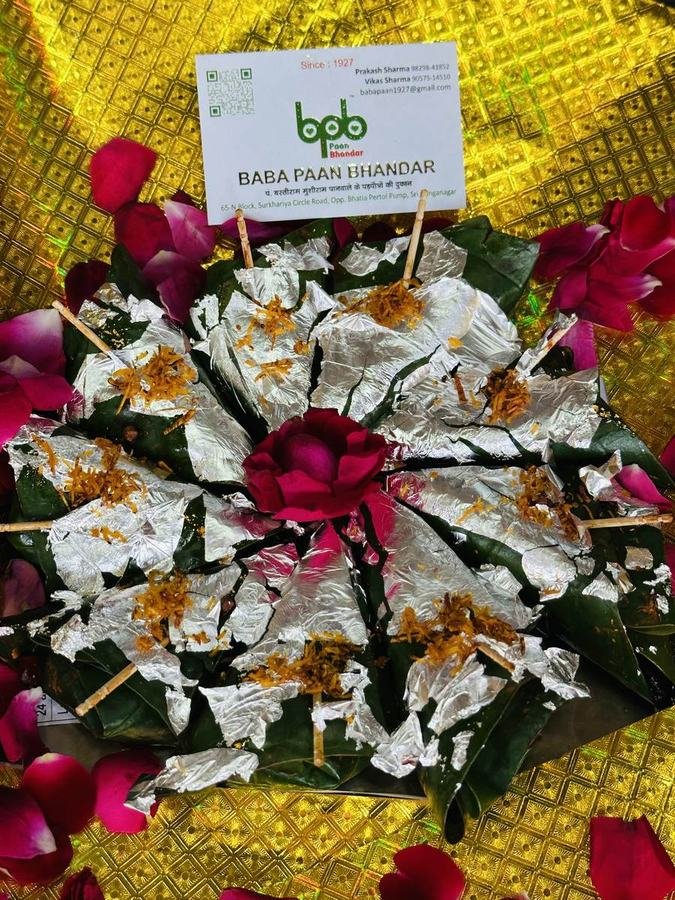 Circular arrangement of silver leaf paan with rose